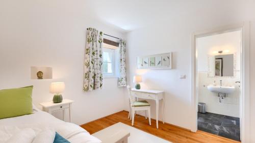 a bedroom with a bed and a desk and a sink at Villa Pigini by Villas Guide in Livade
