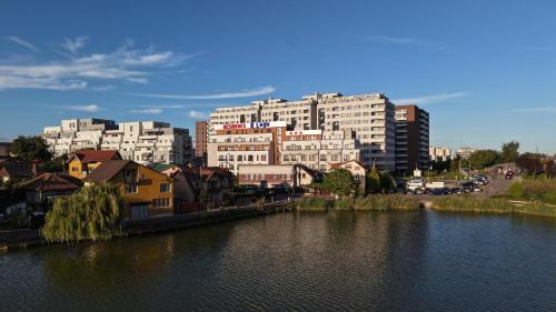 a view of a city with a river and buildings at Residence iL Lago in Cluj-Napoca