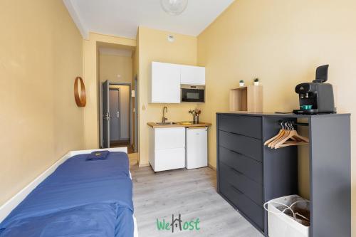 a small room with a bed and a kitchen at Séjour moderne à Besançon in Besançon