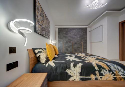 a bedroom with a bed with a black and white comforter at Gozo Getaway! Heated Jacuzzi & Views in Xagħra