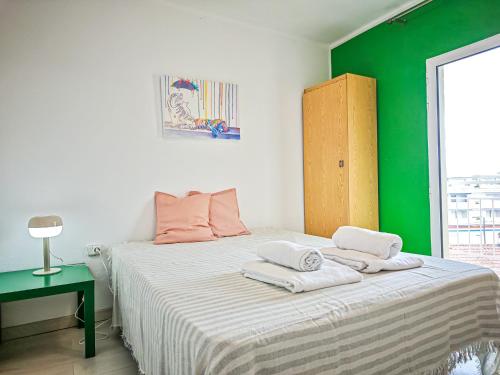 a bedroom with a bed with a green wall at LITORAL COSTA DORADA - CORAL Only families in Cambrils