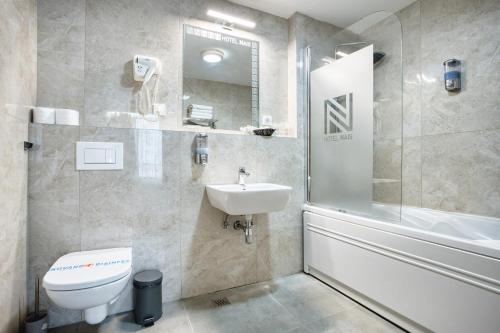 a bathroom with a toilet and a sink and a shower at Hotel Nais Nis Autoput in Niš