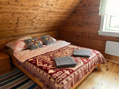a bed in a wooden room with two pillows on it at Brzozowy Zakątek in Waśki