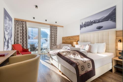 a hotel room with a bed and a desk at Hotel Alpenkönigin - ALPINE LUXURY in See