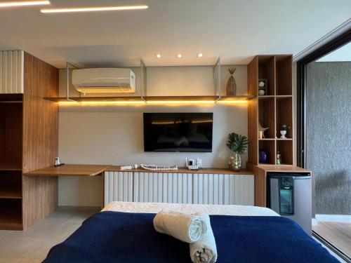 a bedroom with a bed and a tv in it at Flats Beach Class Verano - Muro Alto, Porto de Galinhas in Ipojuca
