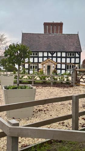 a black and white building with a tree in a fence at Spenford House 1640 listed house Idilic Location pub walking distance in Shrewsbury