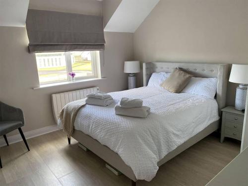 a bedroom with a bed with two towels on it at 3 Bed in Doonbeg oc-ii15918 in Kilrush