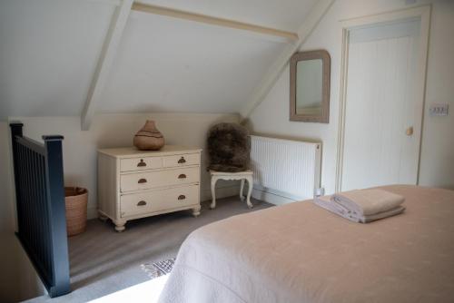 a bedroom with a bed and a dresser and a mirror at The End in Langport