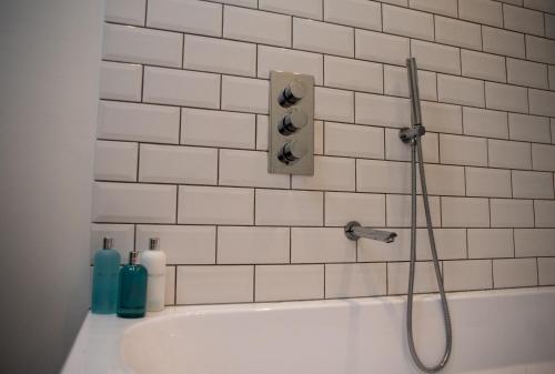 a white bath tub with a shower head and a shower at The End in Langport