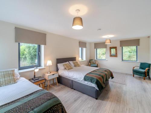 a bedroom with two beds and two chairs and windows at 3 Bed in Pontoon oc-i525 in Pontoon