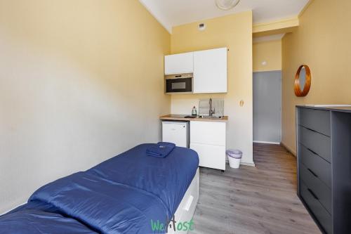 a small room with a bed and a kitchen at Petit cocon confortable à Besançon in Besançon