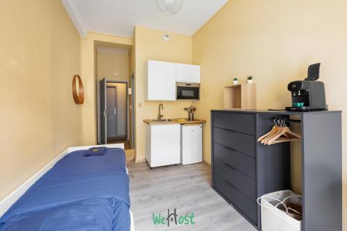 a small room with a bed and a kitchen at Studio élégant et lumineux pour 2 personnes in Besançon