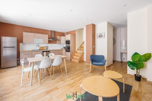 a living room with a table and chairs and a kitchen at Grand T5 lumineux au cœur de Besançon in Besançon