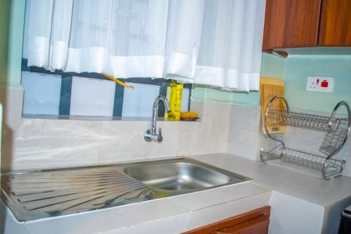 a kitchen counter with a sink and a window at Norlan Homes Kisumu in Kisumu
