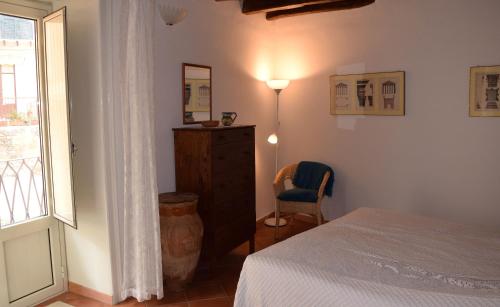 a bedroom with a bed and a dresser and a window at Casa Vacanza Alma in Cefalù