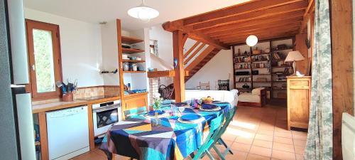 La maison bleue في بيلفيس: مطبخ به طاولة مغطاة بمفرش طاولة أزرق