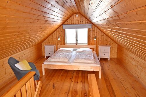 a bed in a wooden room with a window at "Lönnebo" in Lönneberga