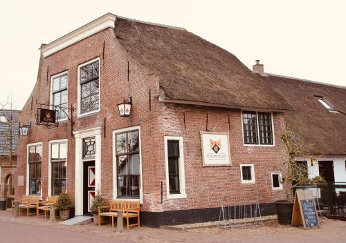 an old brick building with tables and chairs outside at Herberg De Hollandsche Leeuw in Nieuwkoop