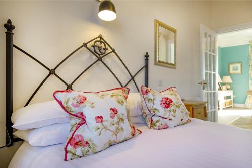 a bedroom with a bed with red and white pillows at Mariners Balcony Apartment in Sidmouth