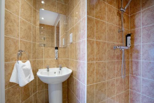 a bathroom with a sink and a shower at Mariners Balcony Apartment in Sidmouth
