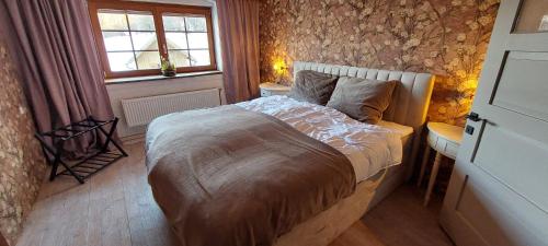 a bedroom with a bed and a stone wall at Landhaus Rickies in Aifersdorf