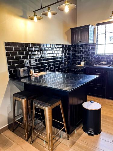a kitchen with a large counter with stools in it at Modern Farm in Lichtenburg