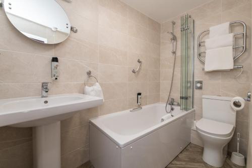 a bathroom with a sink and a tub and a toilet at Wyndham Balcony Apartment in Sidmouth