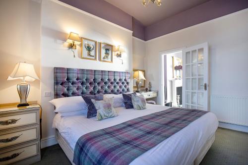 a bedroom with a large bed with a blue headboard at Wyndham Balcony Apartment in Sidmouth