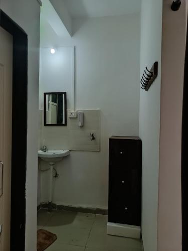 a white bathroom with a sink and a mirror at Dapolihideaway in Dapoli