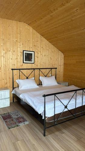 a bed in a room with a wooden wall at Kashmiri kitchens hotel in Gudauri