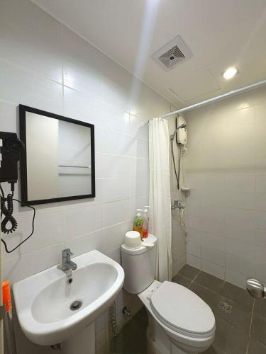 a bathroom with a white toilet and a sink at The Midpoint Residences - Studio Unit in Cebu City