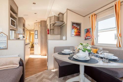 a small kitchen and dining room with a table in a tiny apartment at Peaceful Spot at Seton Sands 3-Bed Caravan near Edinburgh in Port Seton