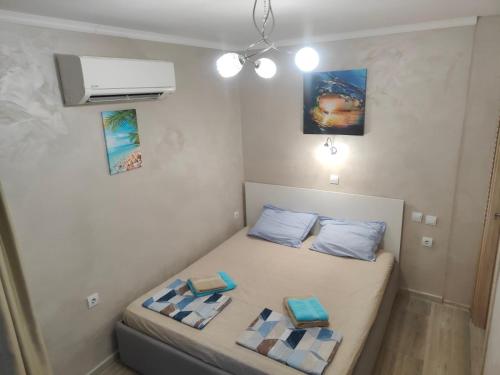 a small bedroom with a bed with two pillows at Лукс Апартамент Морска Перла in Primorsko