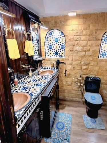 a bathroom with two sinks and a toilet at Ray CaboNegro Sea & Pool View in Cabo Negro