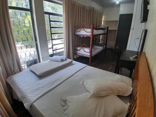 a bedroom with a bed and a large window at Casa de Pedra Mineira in Canela