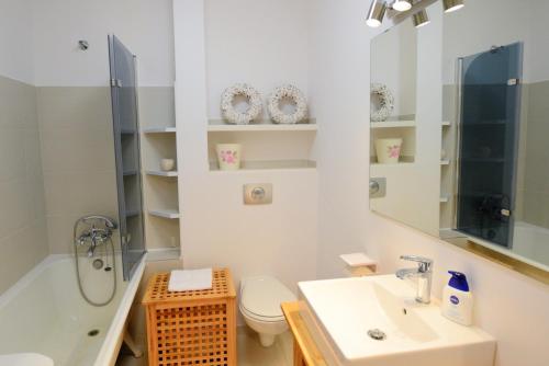 a bathroom with a sink and a toilet and a tub at Quantic Apartment in Warsaw