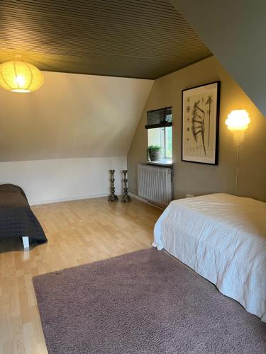 a bedroom with a large bed and a rug at Charming townhouse in CityCenter Townhouse - free parking in Odense