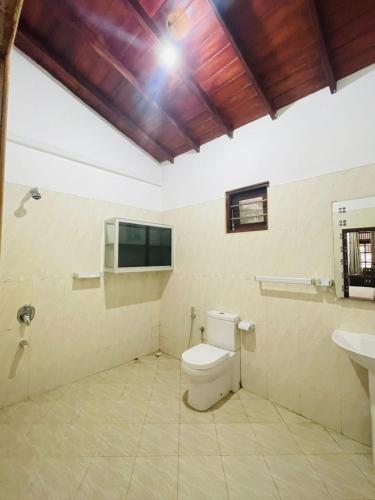 a bathroom with a toilet and a sink at Reef Inn by COOP in Hikkaduwa