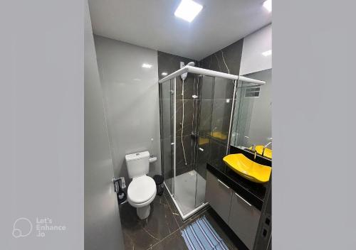 a bathroom with a toilet and a glass shower at Apto elegante no Catolé 77 in Campina Grande