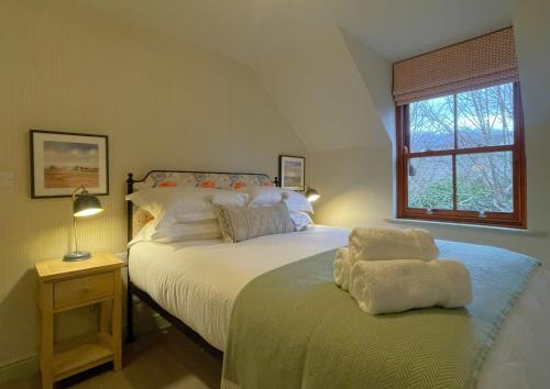 a bedroom with a large bed and a window at Catbells in Keswick