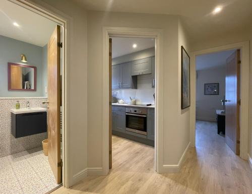 a kitchen with a door open to a room with a sink at Catbells in Keswick