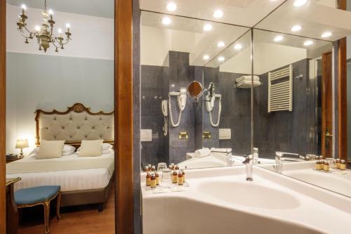a bathroom with a tub and a sink and a bed at Hotel Della Torre Argentina in Rome