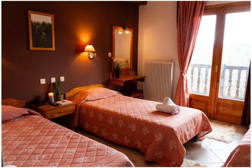 a hotel room with two beds and a window at Milionis Forest Hotel in Grevena