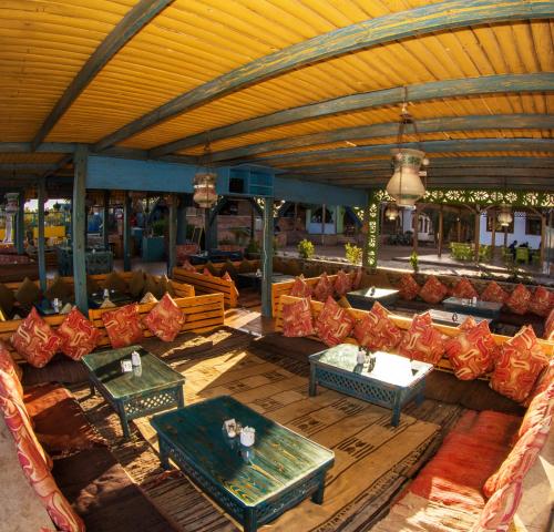 an outdoor seating area with couches and tables at Shams Hotel & Dive Centre in Dahab