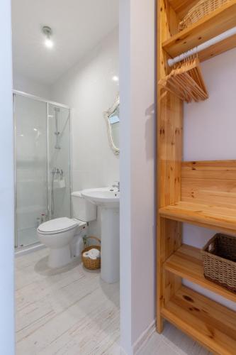 a white bathroom with a toilet and a sink at Garden view in Cascais