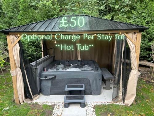 a hot tub in a gazebo with a sign at Airport Hideaway in Manchester