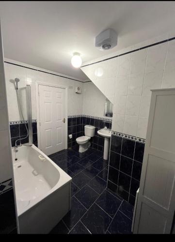 a bathroom with a tub and a toilet and a sink at Large 3 bed Duplex Apartment - Rhebogue Limerick in Limerick