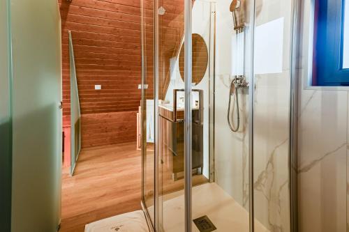 a glass shower in a bathroom with a staircase at Lena Village Hotel and Spa in Mortágua