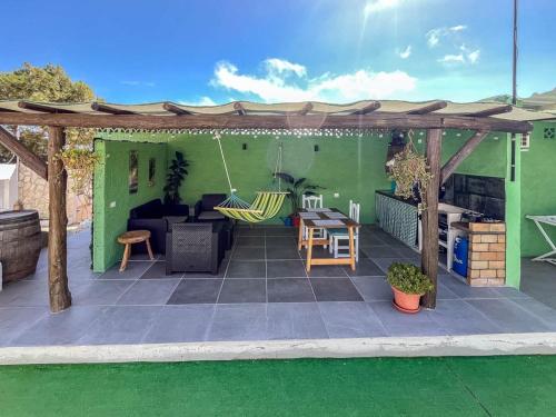 a patio with a green house with a wooden pergola at GuestReady - El Pinar isla del Hierro in El Pinar del Hierro
