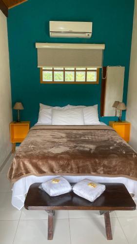 a bedroom with a large bed with two towels on it at Chales Sao Felix in São Bento do Sapucaí
